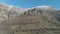 Majestic rock formation on a green mountainside covered by shrubs on a clear sunny day against the blue clear sky. Shot