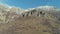 Majestic rock formation on a green mountainside covered by shrubs on a clear sunny day against the blue clear sky. Shot