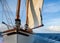 Majestic sailboat sailing on blue sea under billowing clouds