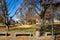 A majestic shot of a autumn landscape in the park with gorgeous autumn colored trees and grass with stone park benches