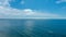 A majestic shot of vast miles of gorgeous blue ocean water with large clouds miles off the coast at Rincon Beach