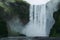 Majestic Skogarfoss waterfall in Iceland. White and green splashes flying all around