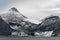 Majestic snow-capped mountains near the seashore against a clouded sky