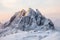 Majestic snowy mountain with mountaineer on snow hill at sunrise