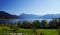 Majestic southern German landscape with blue lake and mountains in the background under a blue sky