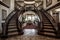 majestic staircase with intricate ironwork railing and plush carpeting