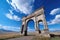 majestic stone archway, with a clear blue sky and fluffy clouds in the background