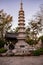 Majestic stone pagoda stands amid lush greenery in a peaceful garden setting