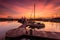 A majestic sunrise with boat resting near the dock as foregrou