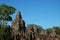 The majestic towers of Bayon Temple, in Cambodia. Tall tropical trees. Beautiful landscape
