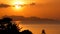 Majestic tropical orange summer real time sunset over sea with mountains silhouettes. Aerial view of dramatic twilight
