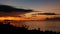 Majestic tropical orange summer timelapse sunset over sea with mountains silhouettes. Aerial view of dramatic twilight