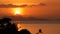 Majestic tropical orange summer timelapse sunset over sea with mountains silhouettes. Aerial view of dramatic twilight