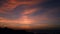 Majestic tropical orange summer timelapse sunset over sea with mountains silhouettes. Aerial view of dramatic twilight