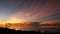 Majestic tropical orange summer timelapse sunset over sea with mountains silhouettes. Aerial view of dramatic twilight