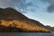 Majestic vibrant Autumn Fall landscape Buttermere in Lake District with beautiful early morning sunlight playing across the hills