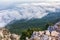 A majestic view of the rocky mountains and the valley in fog and clouds. Creamy fog covered the mountain valley in sunset light.