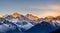 majestic view of the snow-capped peaks of the Great Himalayan National Park, illuminated by the golden light of the setting sun.