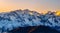 majestic view of the snow-capped peaks of the Great Himalayan National Park, illuminated by the golden light of the setting sun.