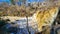 a majestic waterfall with bare winter trees, lush green plants and water flowing along Big Creek River at Vickery Creek Falls