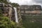 majestic waterfall cascading over cliff, with view of the valley below