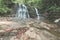 Majestic waterfall in the dense rainforest of Kubah National Park, West Sarawak, Borneo, Malaysia. Desaturated and toned image, in