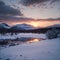 Majestic Winter landscape image looking towards Scottish Highlands mountain range across Loch Ba on Rannoch Moor made