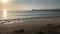 Majorca morning. Wooden pier in Playa de Muro beach. Sunlight reflections on sea