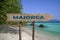 Majorca wooden arrow road sign against beach with white sand and turquoise water background. Travel to Mallorca concept