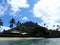 Makalei Beach with waves lapping, napakaa, lava rock wall and Coconut trees along the shore