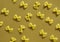 Makaroni or pasta bow shape in row on the brown background