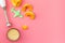 Make baby food at home. Puree with pumpkin near immersion blender, pacifier, toy on pink background top view copy space