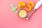 Make baby food at home. Puree with pumpkin near immersion blender, toy on pink background top view copy space
