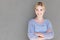 Make happiness a habit. Portrait of a confident young woman standing against a gray background.