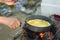 Make an omelette on the pan in hot oil, place on the stove, prepare breakfast for hiking or camping using as travel concept.