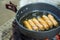 Make an sausage on the pan in hot oil, place on the stove, prepare breakfast for hiking or camping using as travel concept.