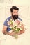 Make surprise concept. Gift for spouse. Bearded hipster in bed. Spring in bedroom. Man hold tulips bouquet while