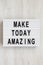 `Make today amazing` words on a modern board on a white wooden surface. From above, overhead, flat lay, top view. Close-up