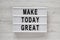 `Make today great` words on a lightbox over white wooden surface, top view. Overhead, from above.