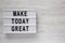`Make today great` words on  modern board over white wooden background, top view. Overhead, from above. Flat lay. Copy space