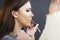 A make-up artist is applying makeup to a young girl.