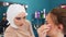 The make-up artist carefully sticks eyelashes, a brunette girl in a beauty salon