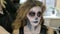Make-up artist make the girl halloween make up in studio.Halloween face art.Woman applies on professional