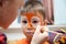 Make up artist making tiger mask for child