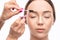 Make-up artist plucks eyebrows with tweezers to a woman before staining with henna.Makeup concept, eyebrow shape modeling and