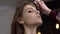 Make-up artist puts powder on face, model talks