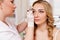 Make up and beauty concept - cosmetologist  painting eyebrows at beauty studio