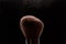 Make-up brush with beige powder explosion on black background. Creative splash. Professional powder