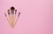 Make up brush sets arranged on pink background, top view with co