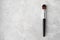 Make up brush with synthetic bristles and black wood handle on luxury marble background. Cosmetic brush for face tone, blush,